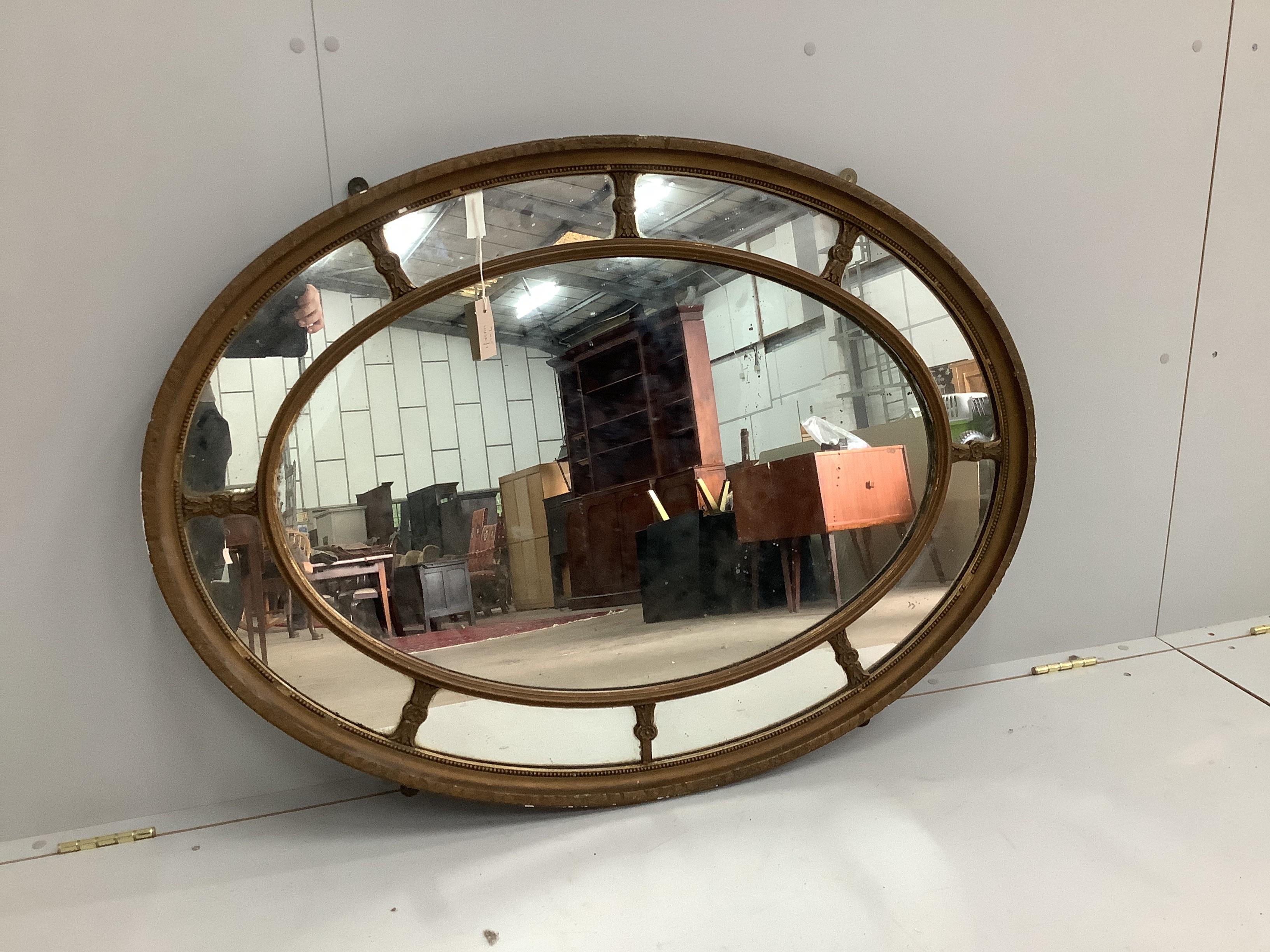 An early 20th century oval giltwood and composition marginal plate wall mirror, width 111cm, height 82cm